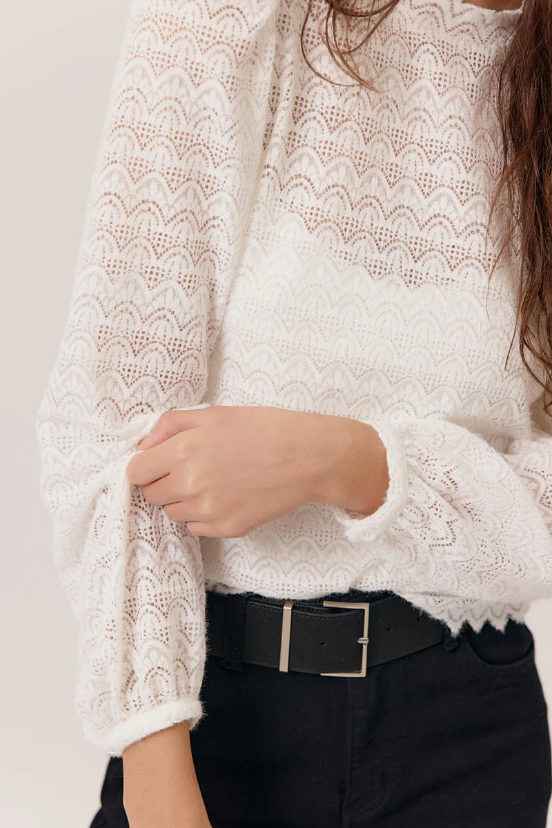 Détail de manches de la Blouse Wendy de Artlove , en dentelle blanche pour femme, look chic et bohème, portée avec un jean taille haute et bottines