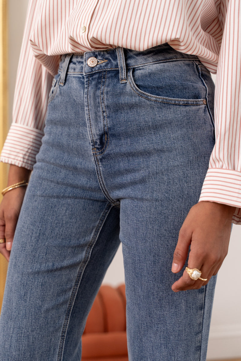 Détail jean denim EMILY, coloris bleu à la taille mi-haute, poches avant et fermeture braguette et bouton de chez ORAIJE