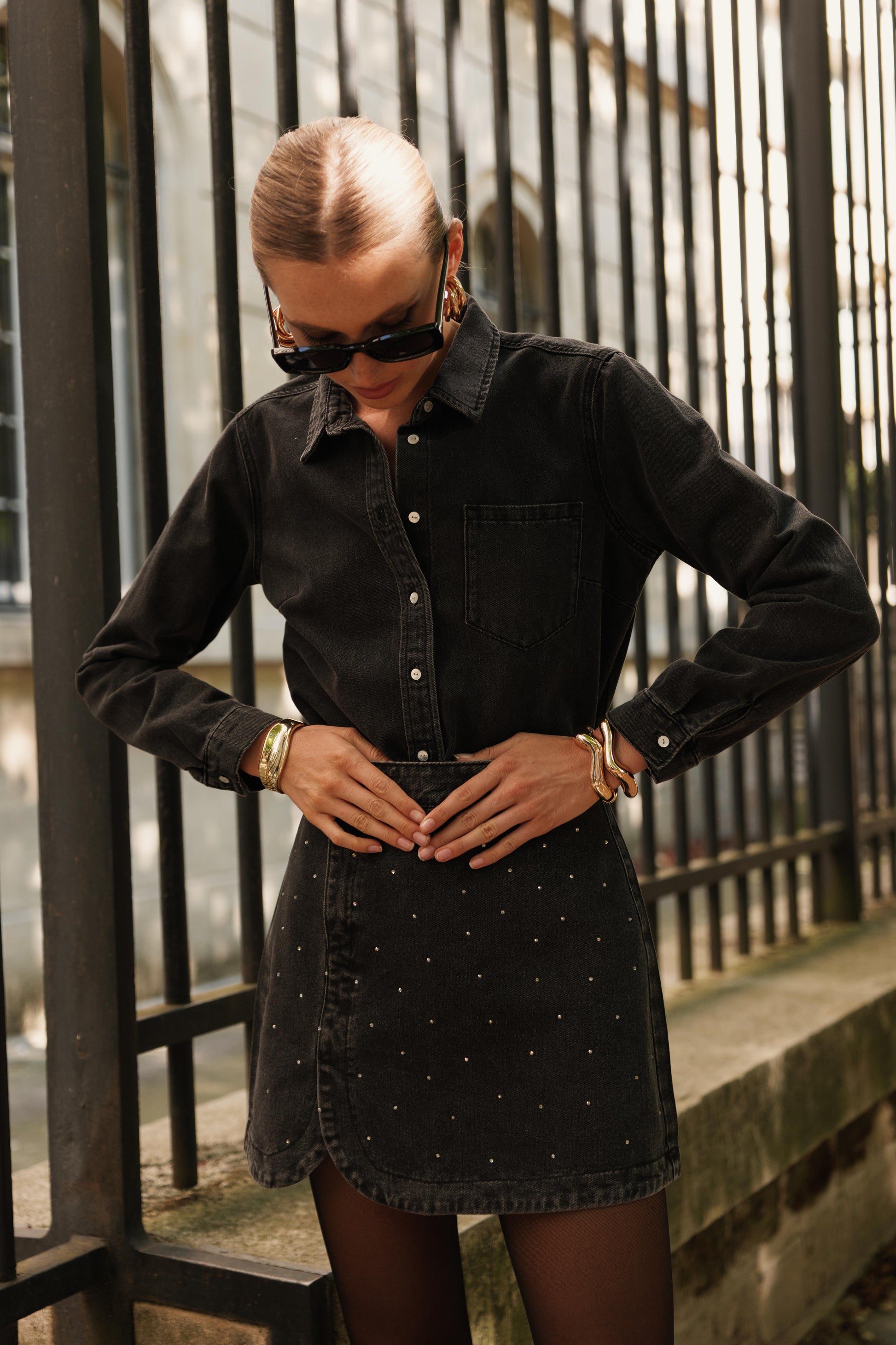 Autre vu du look porté de la Jupe noire JUSTINE en denim délavé avec strass, look mode féminin avec chemise noire rentrée, silhouette affirmée et actuelle de chez ORAIJE