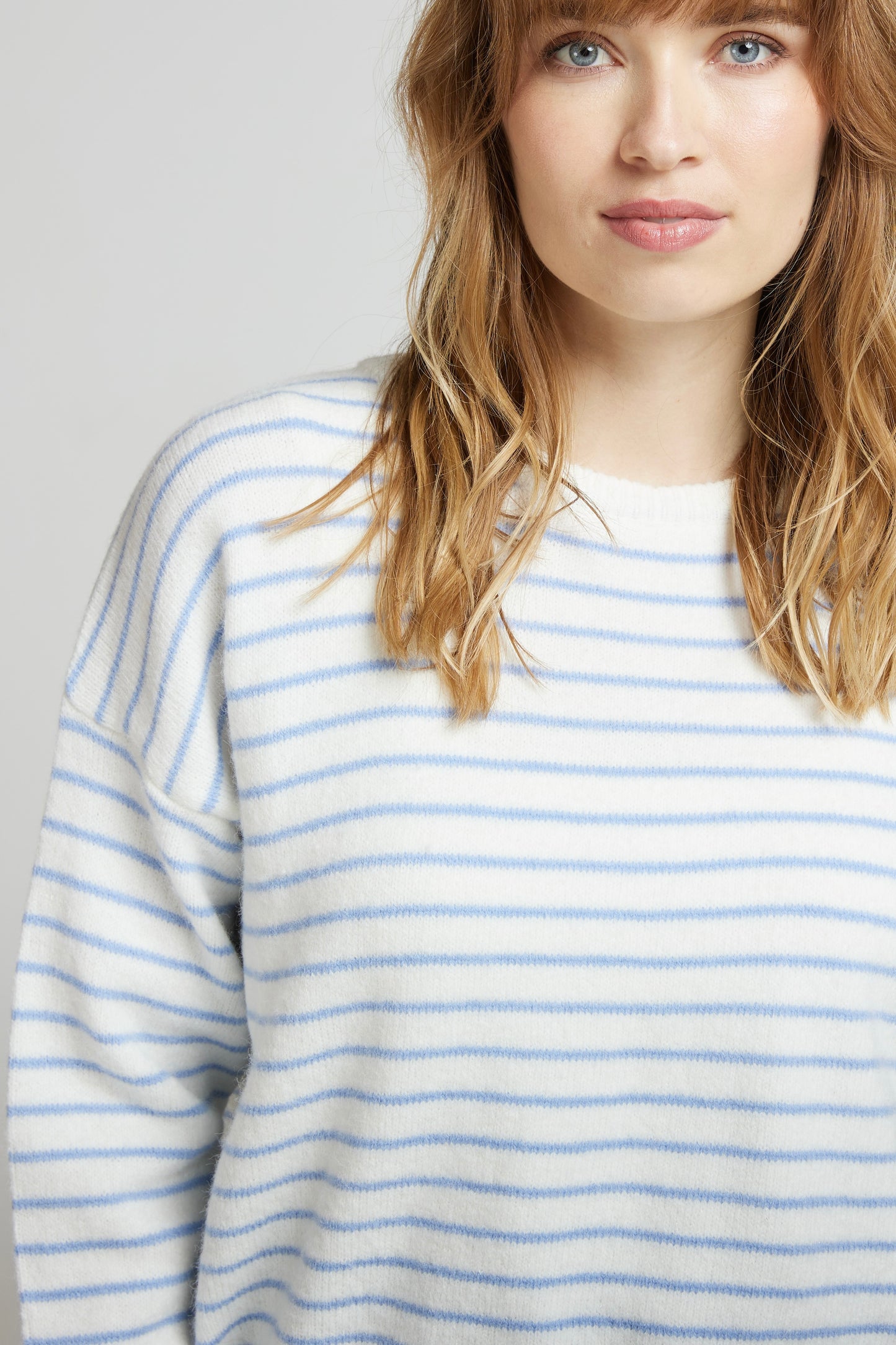 Détail du pull crème à fines rayures ciel GAUTHIER, maille douce et col rond, porté près du visage de  chez Andy et Lucy