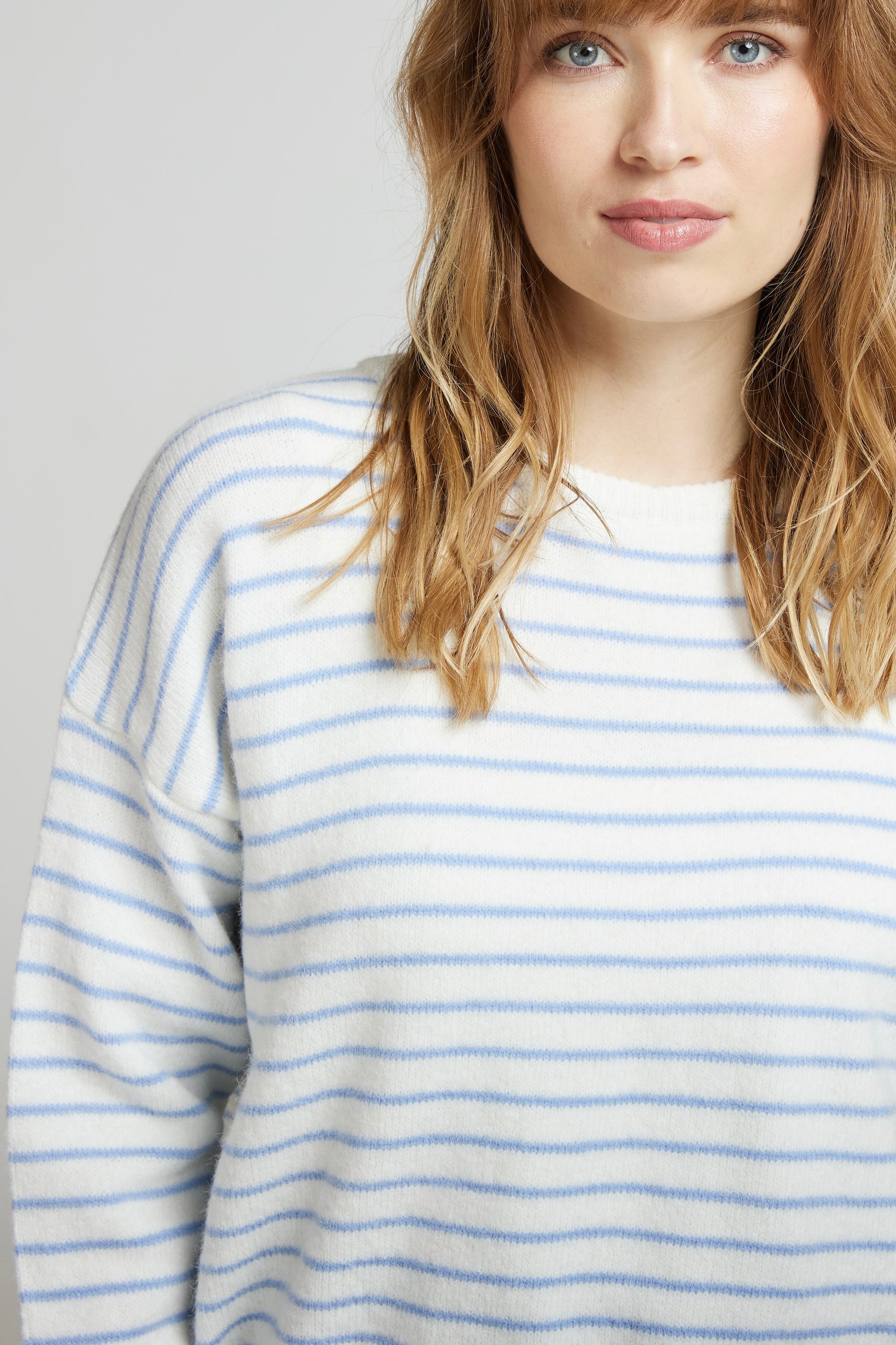 Détail du pull crème à fines rayures ciel GAUTHIER, maille douce et col rond, porté près du visage de  chez Andy et Lucy