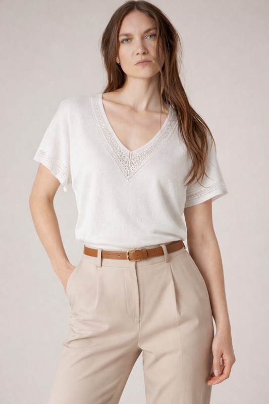 Pull blanc irisé MARLYN porté à même la peau, col V avec finition crochet ajourée qui capte la lumière et adoucit la silhouette de Deeluxe