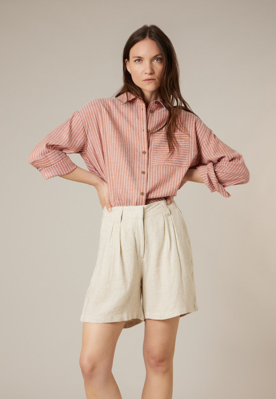 Look avec le short JUNON écru taille haute porté avec une chemise rentrée pour une tenue d’été chic, féminin et décontractée de DEELUXE