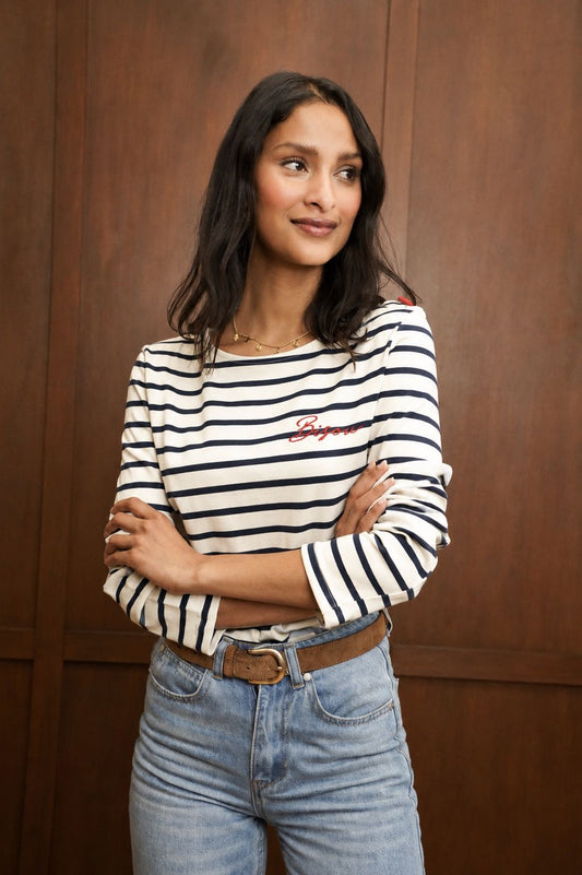 Top marinière femme BISOU à rayures bleu marine et fond beige, broderie rouge sur la poitrine, porté avec un jean bleu de Jubylee